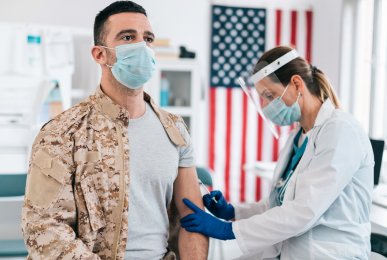 Nurse vaccinates a soldier with COVID-19 vaccine