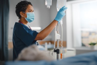 Professional nurse does checkup of patient's intravenous and IV fluid bag